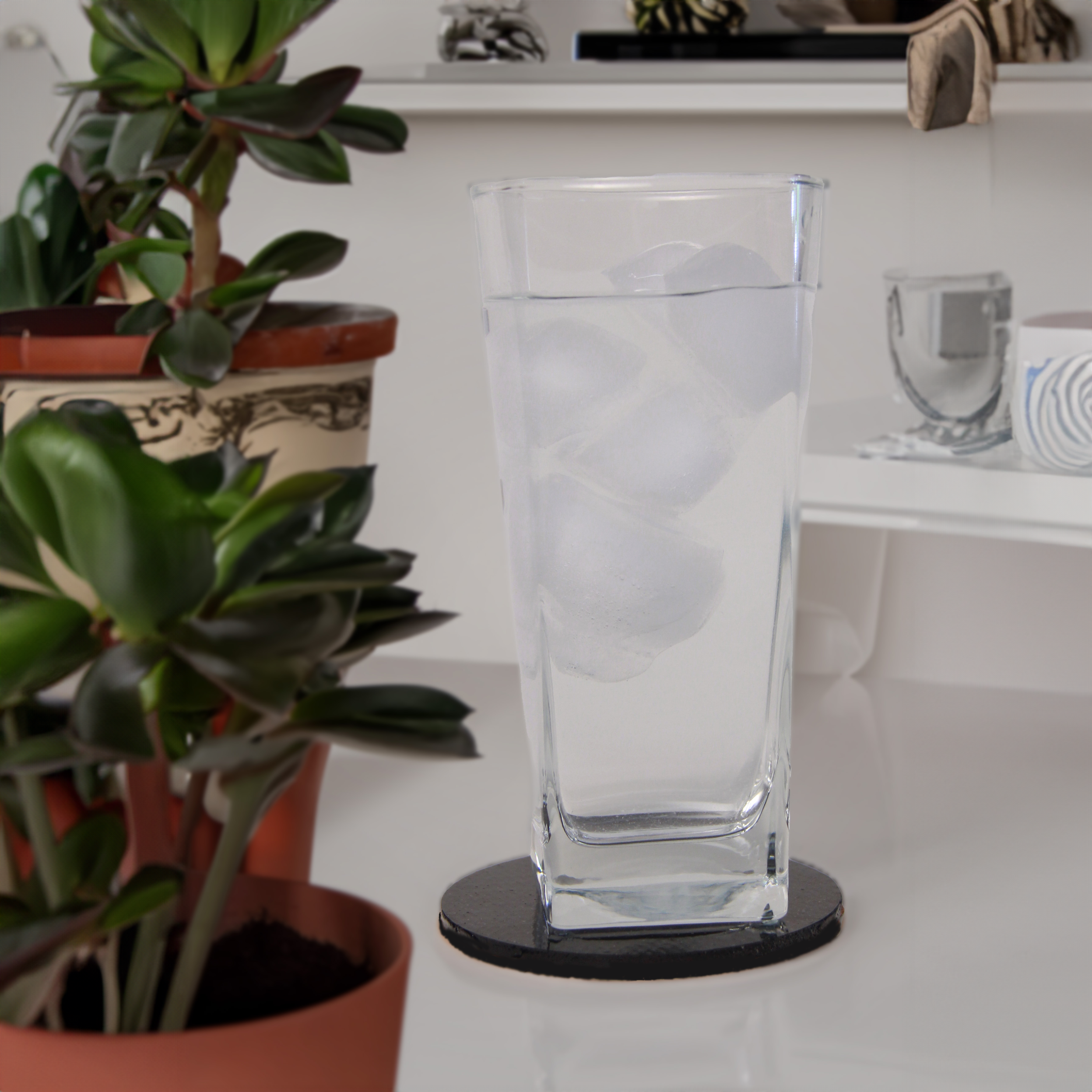 A glass of water on a KLŌS carbon fiber coaster 