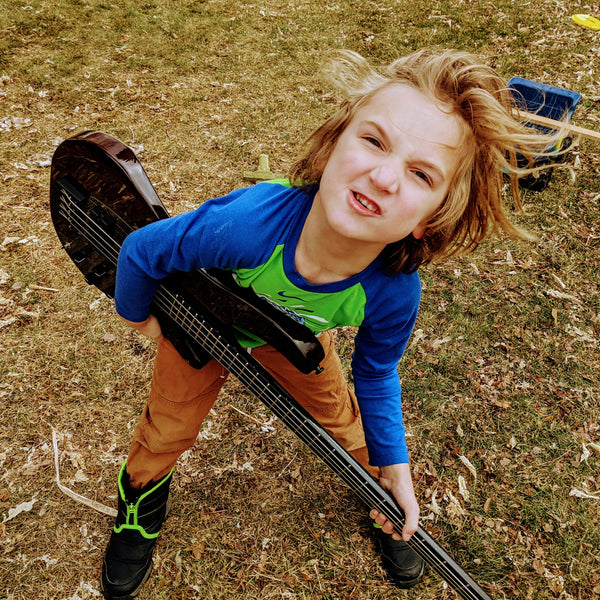Child playing with a KLOS Apollo Bass Outside