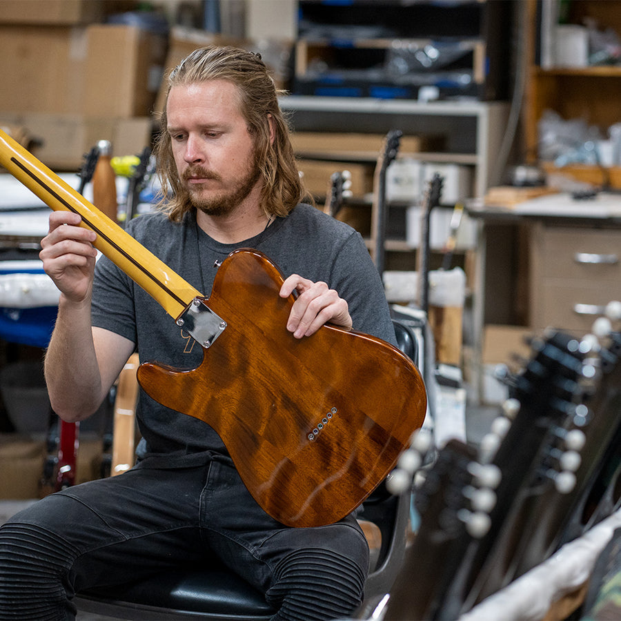 KLŌS Luthier adjusting a non-KLŌS instrument 