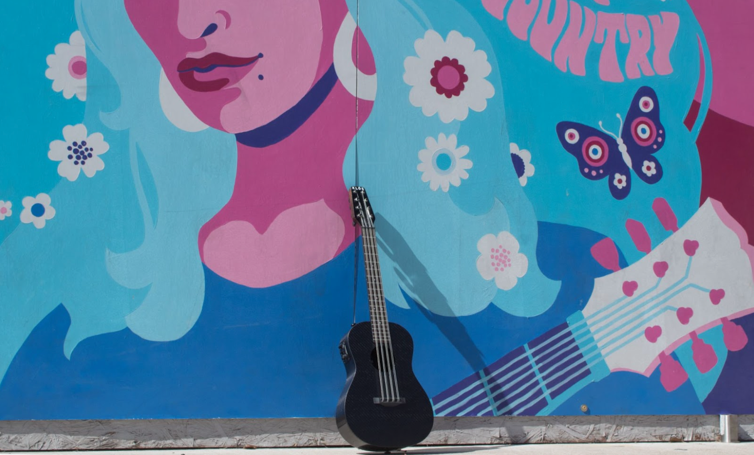 An 8-string uke in front of a colorful background 